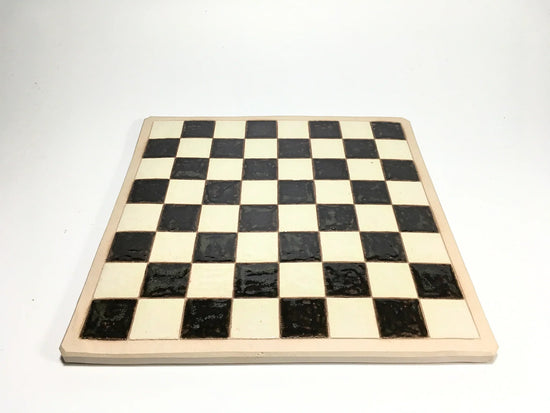 Handcrafted clay chessboard with black and white squares, perfect for creative play